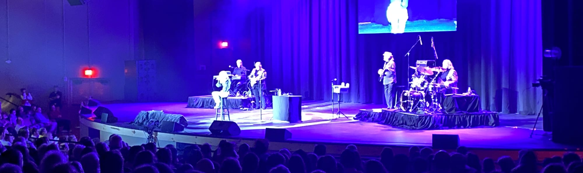 signer on stage in chair washed out by the lights Rochester